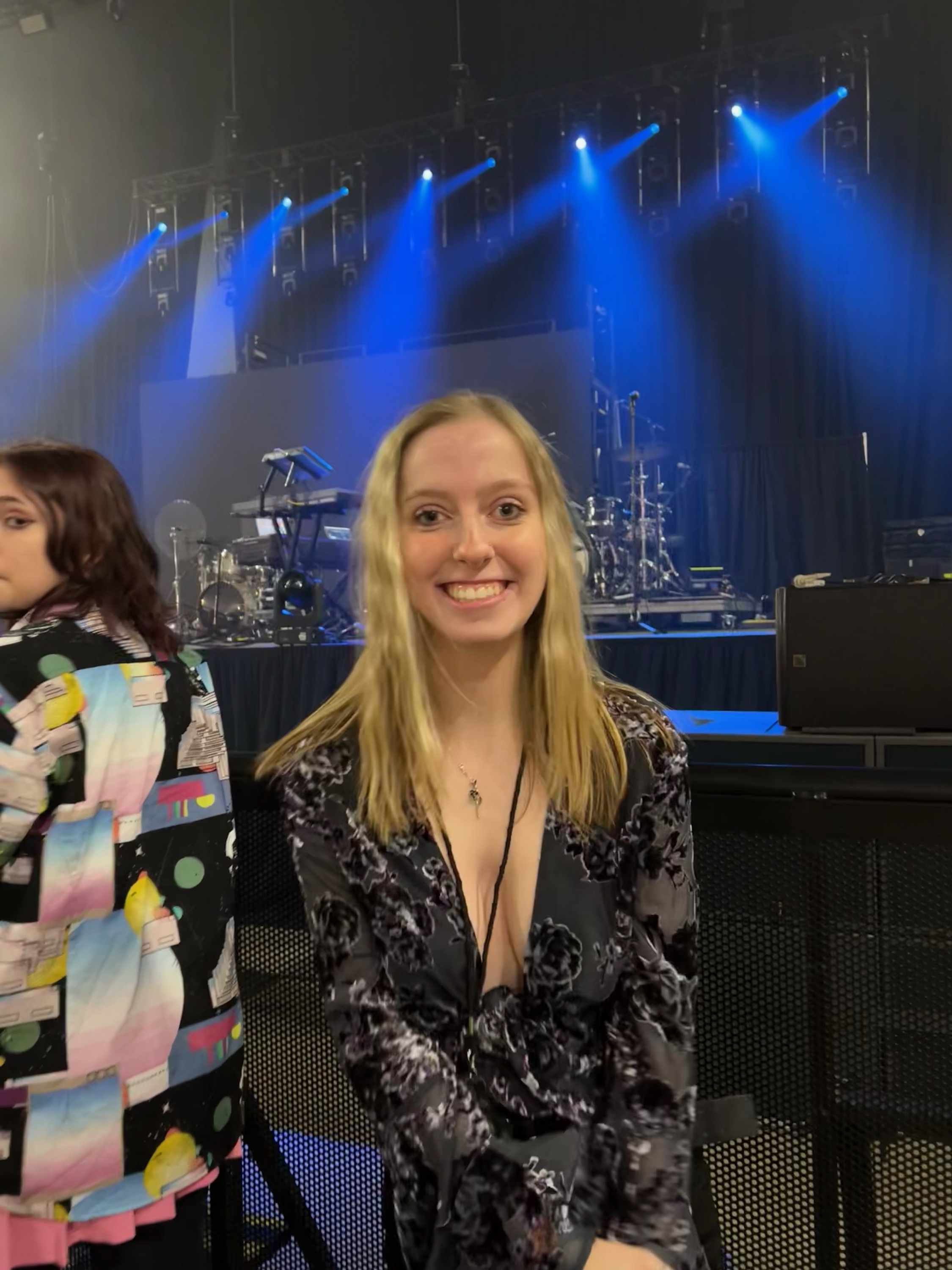 Sydney smiling by the stage at a Conan Gray concert